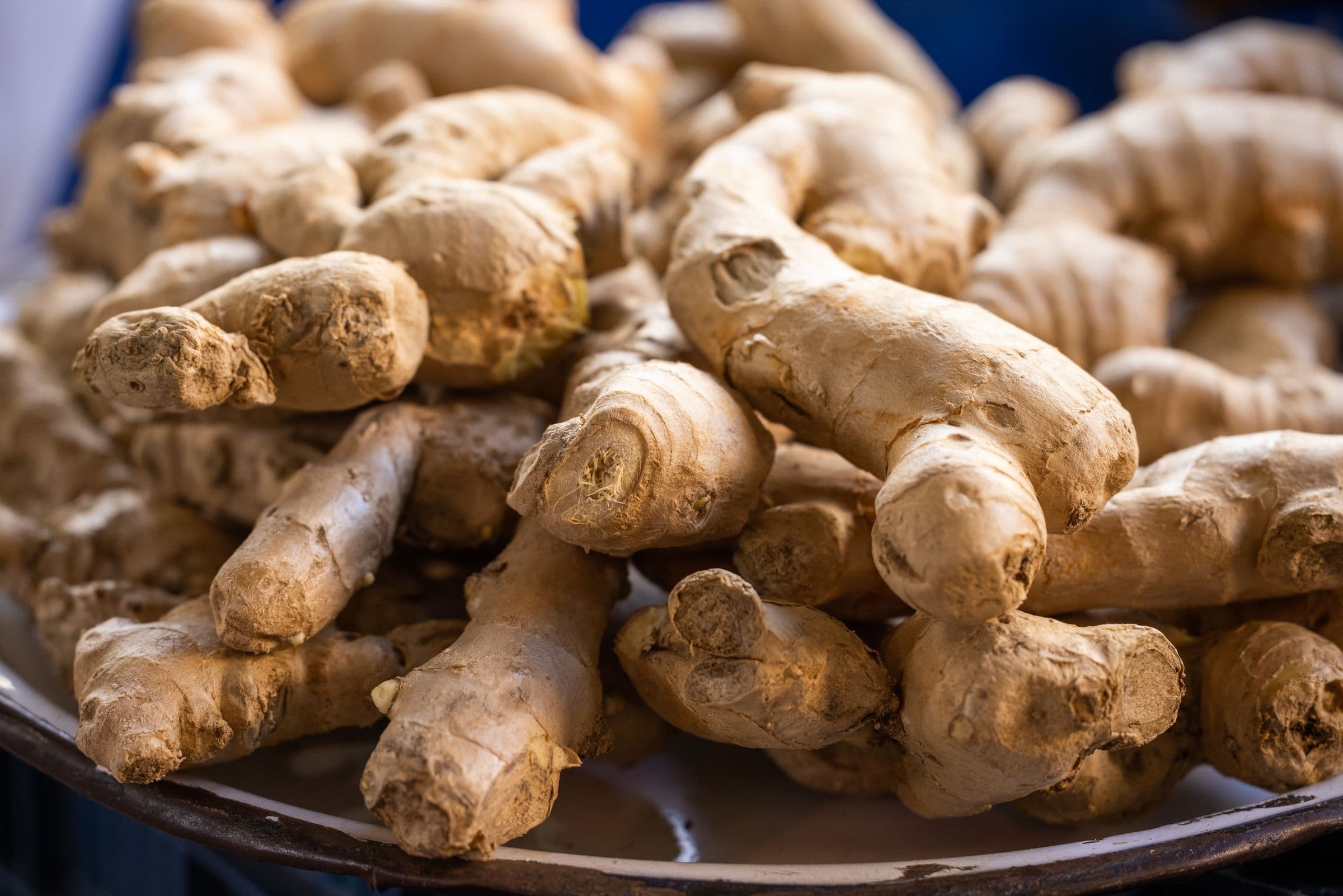 Pile of fresh ginger root on a white plate